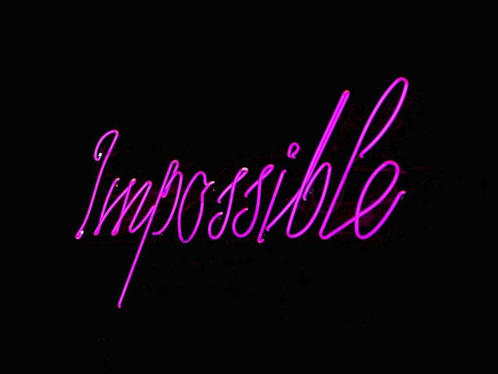 Eye-catching neon 'Impossible' sign glowing against a dark backdrop, perfect for inspirational themes.