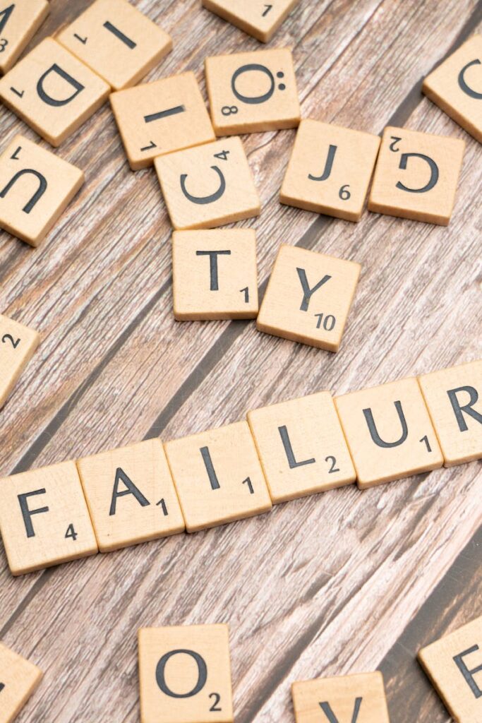 Wooden letter tiles spelling 'failure' on a wooden table, representing challenges.